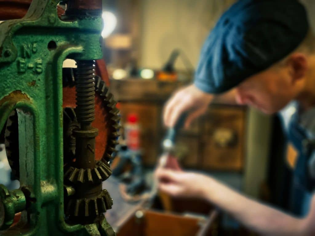 A craftsman working with machinery, symbolizing GiftAider's support for vocational training programs through optimized Gift Aid claims.